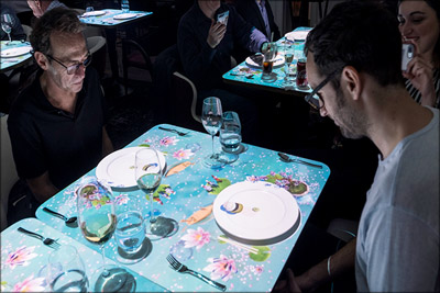 Le Petit Chef Toronto Unique Dinner and Theater Experience Guests enjoying the Le Petit Chef Toronto dinner and theater experience with 3D animated storytelling projected onto the table.